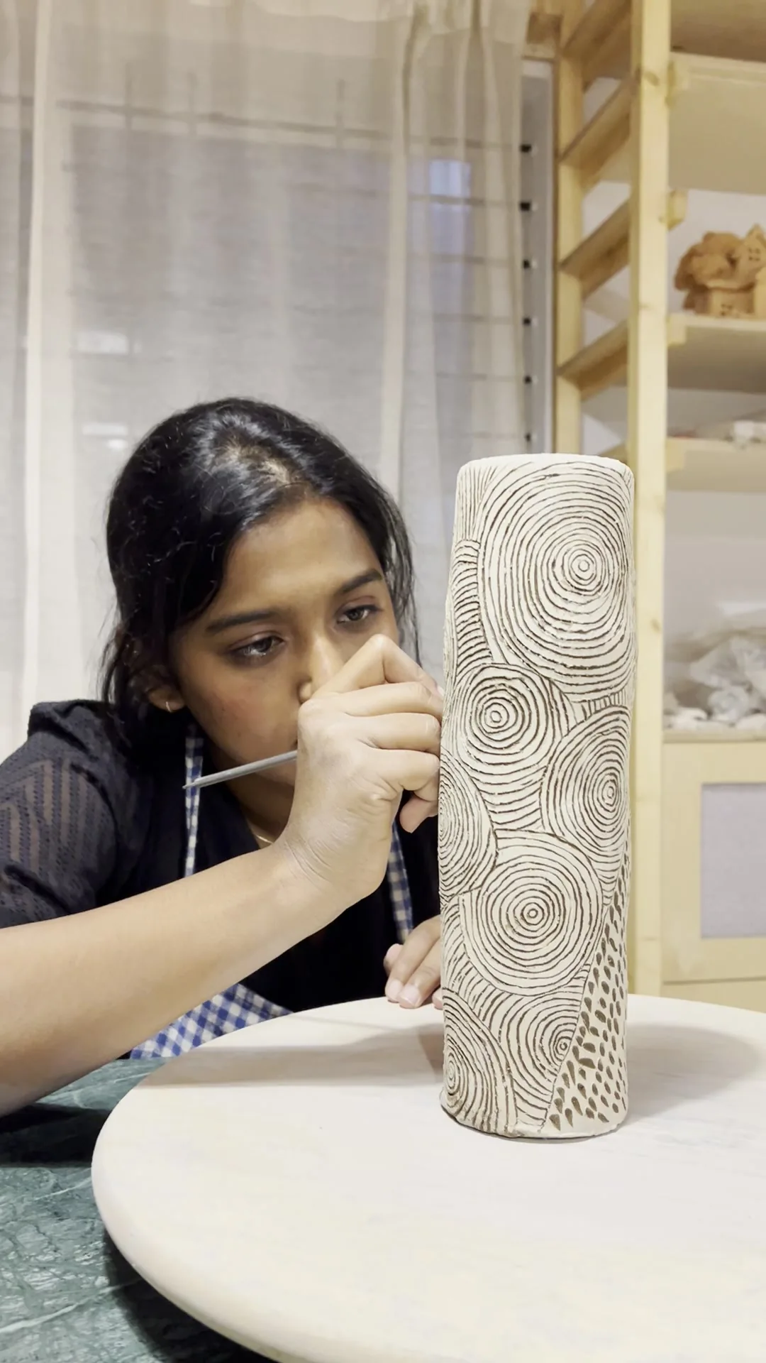 Logisa, Founder of Mann Mozhi, carving ceramic sgraffito patterns